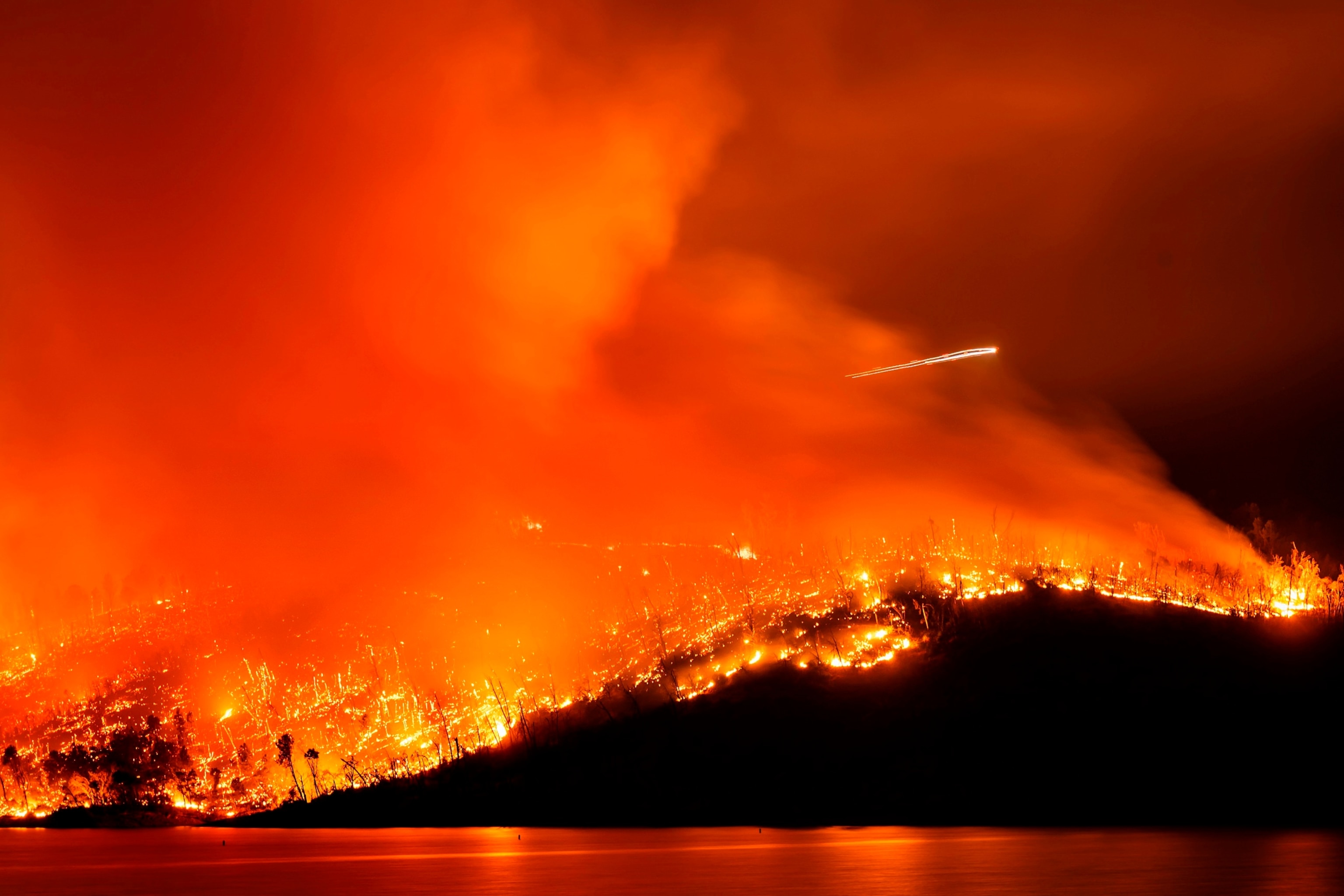 PHOTO: A helicopter flies over the Thompson Fire as it burns above Lake Oroville in Oroville, Calif., Tuesday, July 2, 2024.