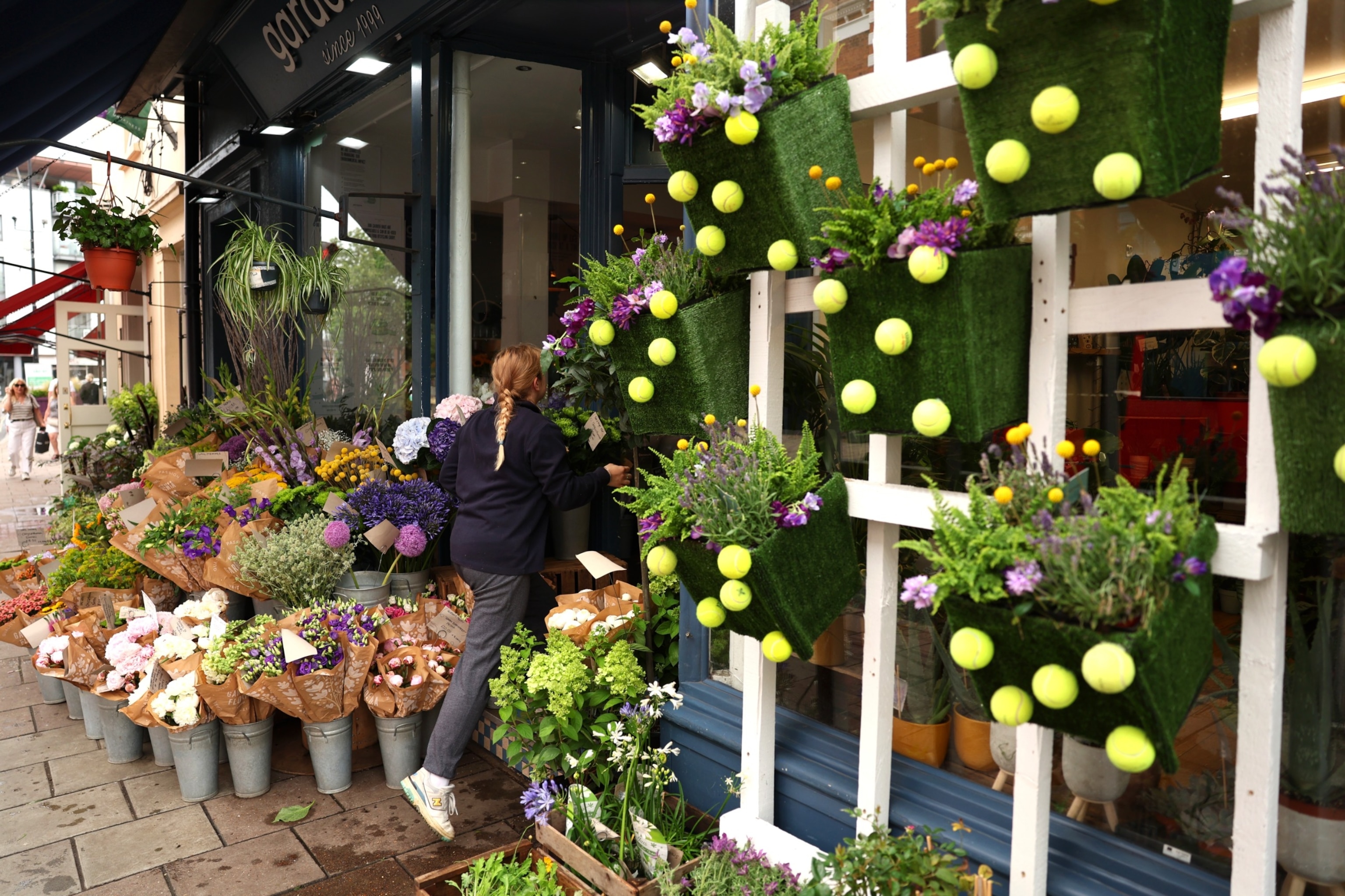 PHOTO: Tennis ball decorations are seen on plant pots outside of a shop in Wimbledon village during day six of The Championships Wimbledon 2023 at All England Lawn Tennis and Croquet Club on July 8, 2023 in London.