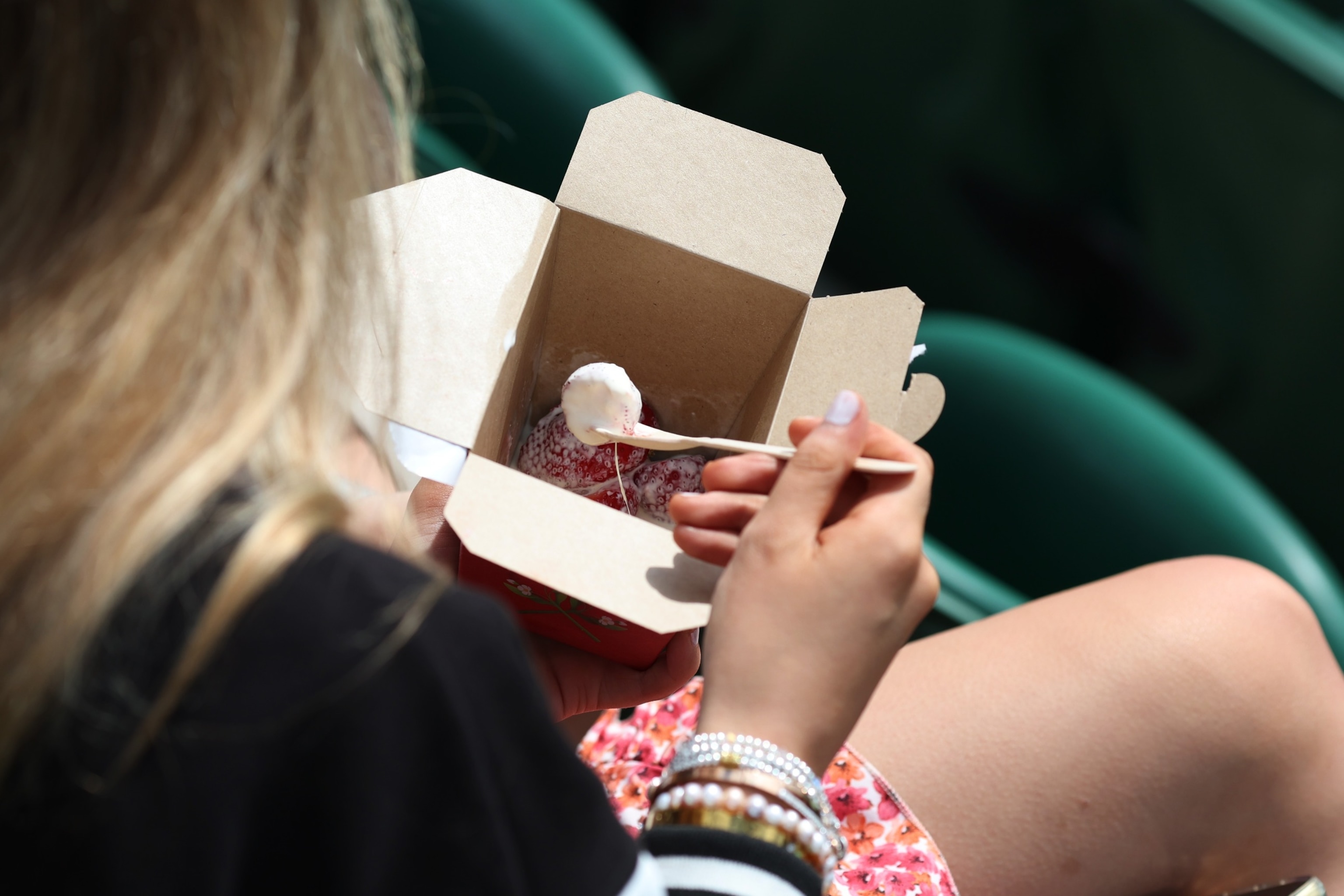 PHOTO: A spectator with strawberries and cream during day three of The Championships Wimbledon 2023 at All England Lawn Tennis and Croquet Club on July 5, 2023 in London.